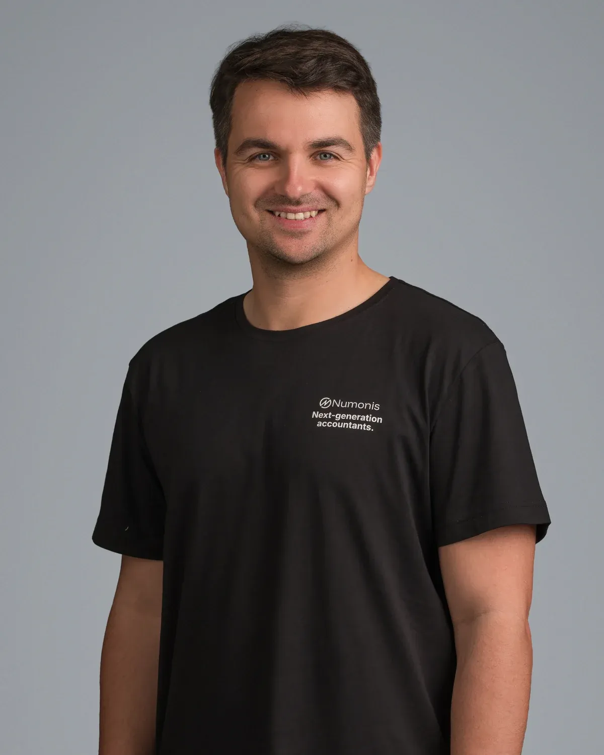 Retrato de Radek Bulat, cofundador de Numonis, con una camiseta negra de Numonis sobre fondo gris